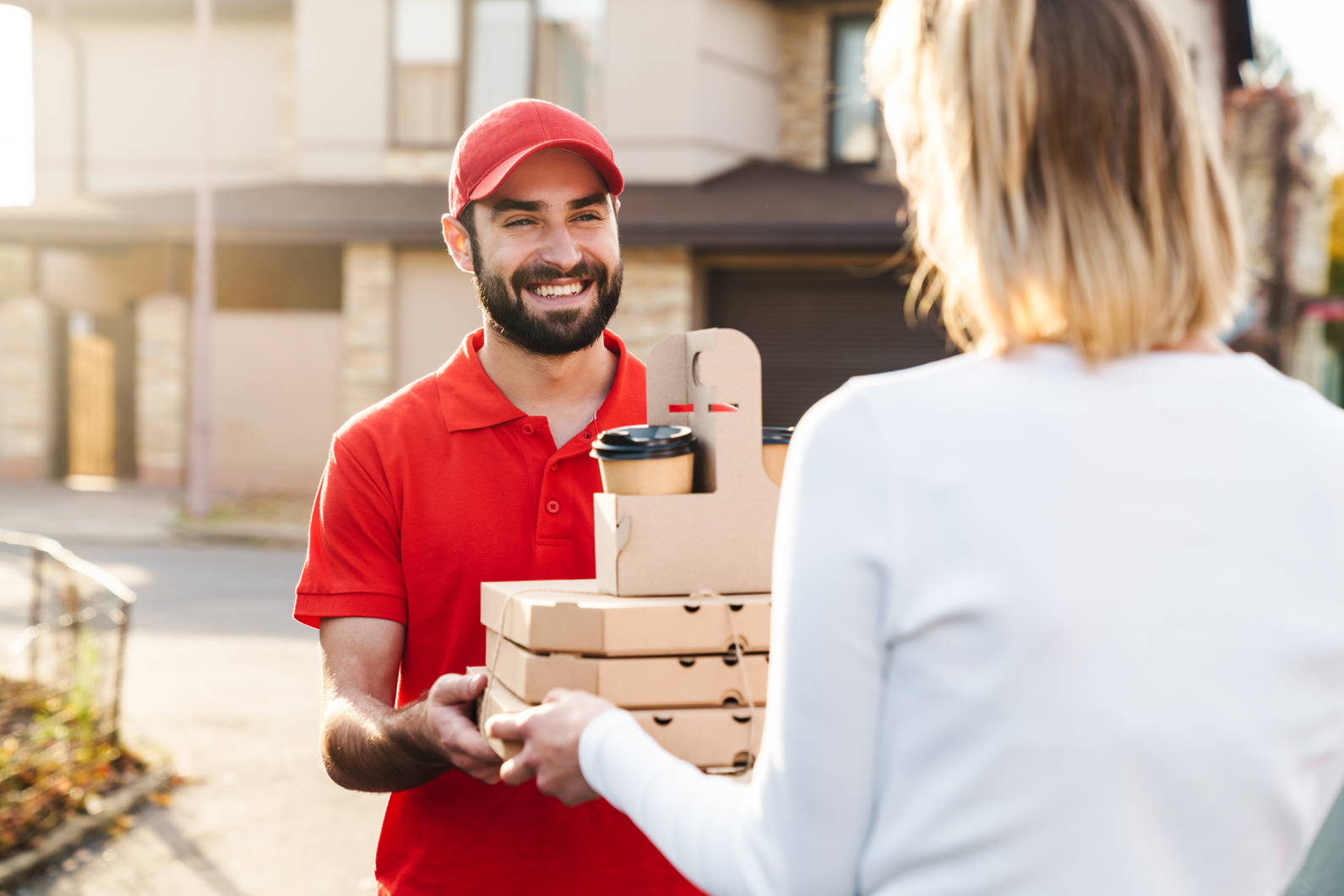 Image of Smiling Delivery Man Giving Food Order to Caucasian Woman